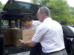 Bob Daria and Manav Lalwani of American Spraytech load products destined for homeless vets.